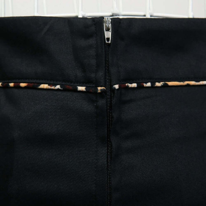 Back view of the black pencil skirt featuring leopard piping and a sleek zip closure.